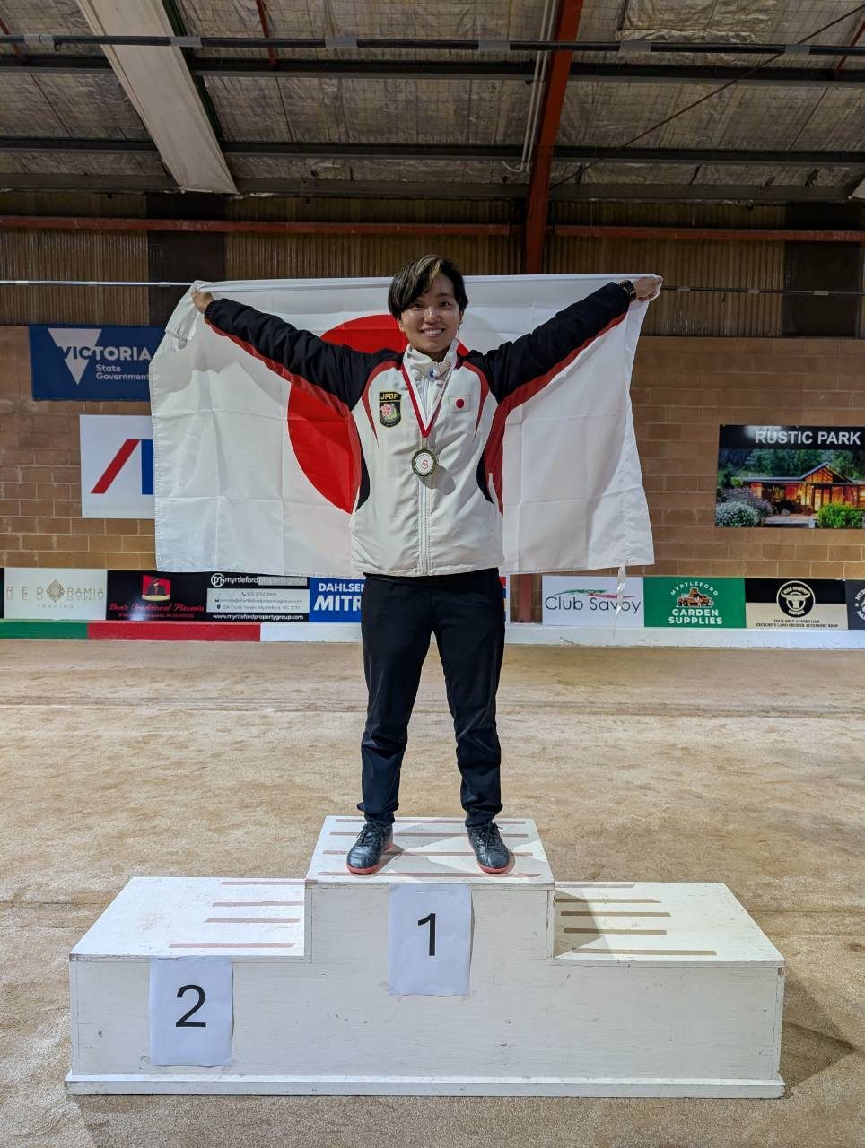 表彰台で日の丸を掲げる久保田結さん